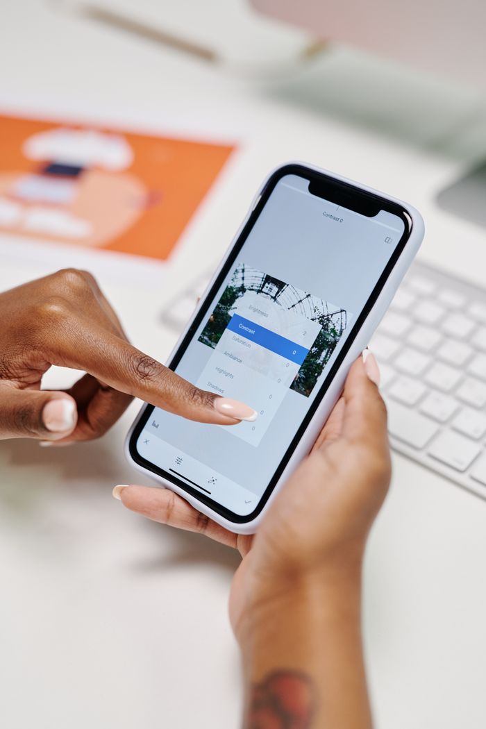 Gros plan sur des mains utilisant un smartphone pour la prise de rendez-vous en ligne, illustrant la praticité du numérique moderne.